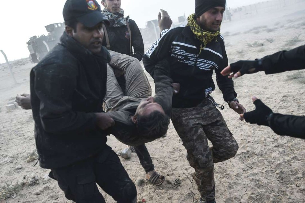 Iraqi Counter Terrorism Section members carry an injured comrade during clashes with Islamic State. Photo: AFP