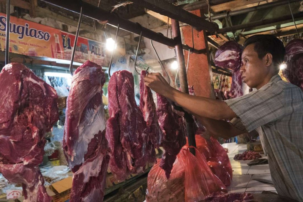 A butcher handles cuts of beef at a stall inside the Jati Asih wet market in Bekasi, West Java, Indonesia. Photo: Bloomberg