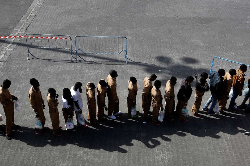 Migrants wait in line after disembarking from a Spanish Navy cruiser in the Sicilian harbour of Catania, Italy, last week. Photo: Reuters