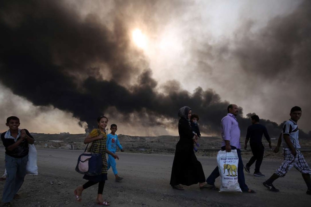Displaced Iraqi families arrive at a checkpoint east of Mosul as they flee fighting last week. Photo: AFP