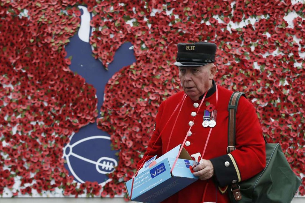 A Chelsea Pensioner pays his respects at the Poppy Wall outside Tottenham Hotspur’s White Hart Lane. Photo: Reuters