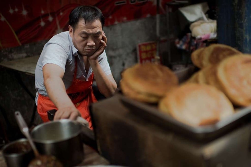 A food vendor waits for customers in Zhengzhou. Local government revenues are at risk of declining as the economy slows. Photo: AFP