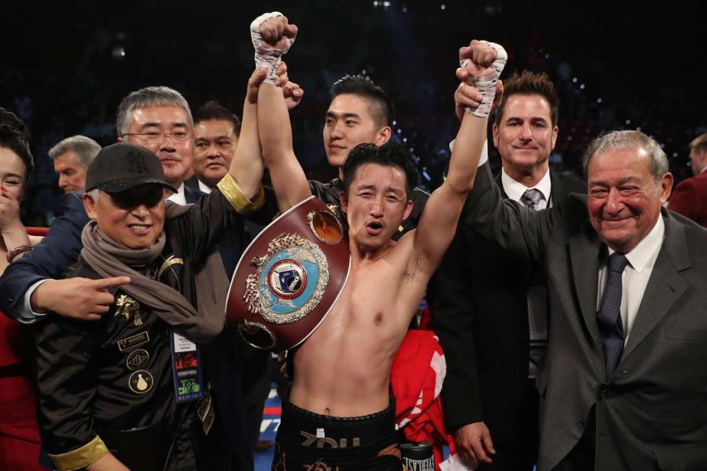 Zou Shiming of China poses with his wife, Yingying Ran, Top Rank Founder and CEO Bob Arum, and his team after his unanimous-decision victory over Prasitsak Phaprom of Thailand during their WBO flyweight championship fight at the Thomas & Mack Centre in Las Vegas. Photo: AFP