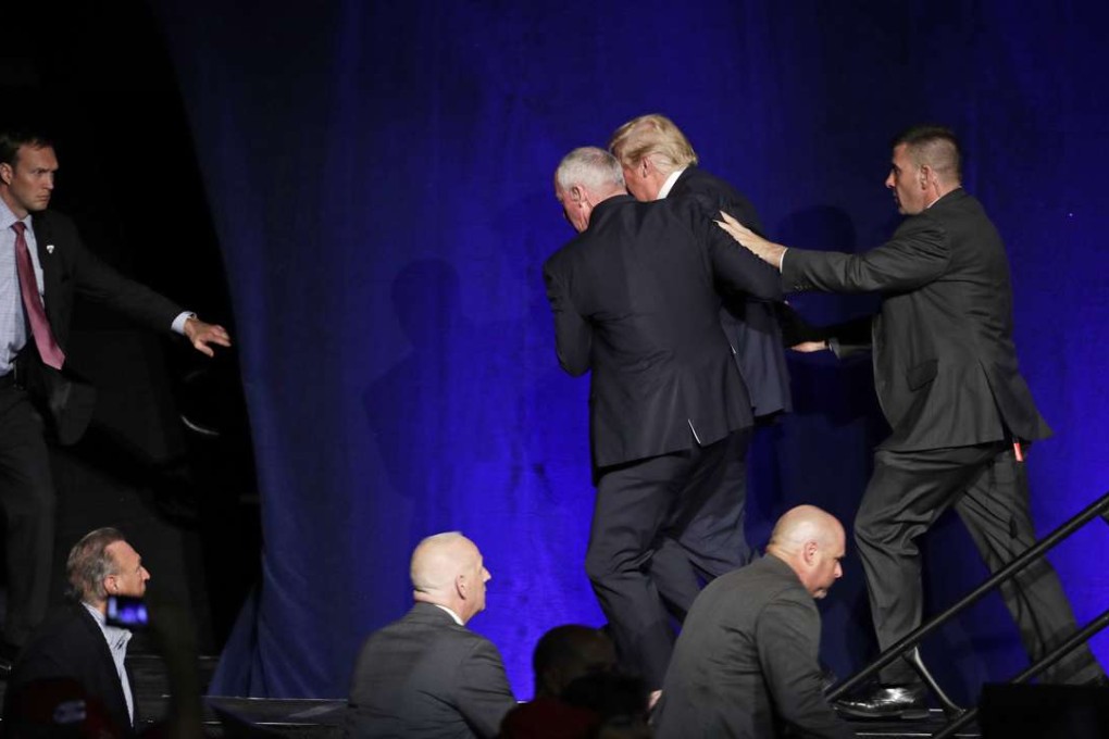 Members of the Secret Service rush Republican presidential candidate Donald Trump off the stage at a campaign rally in Reno. Photo: AP
