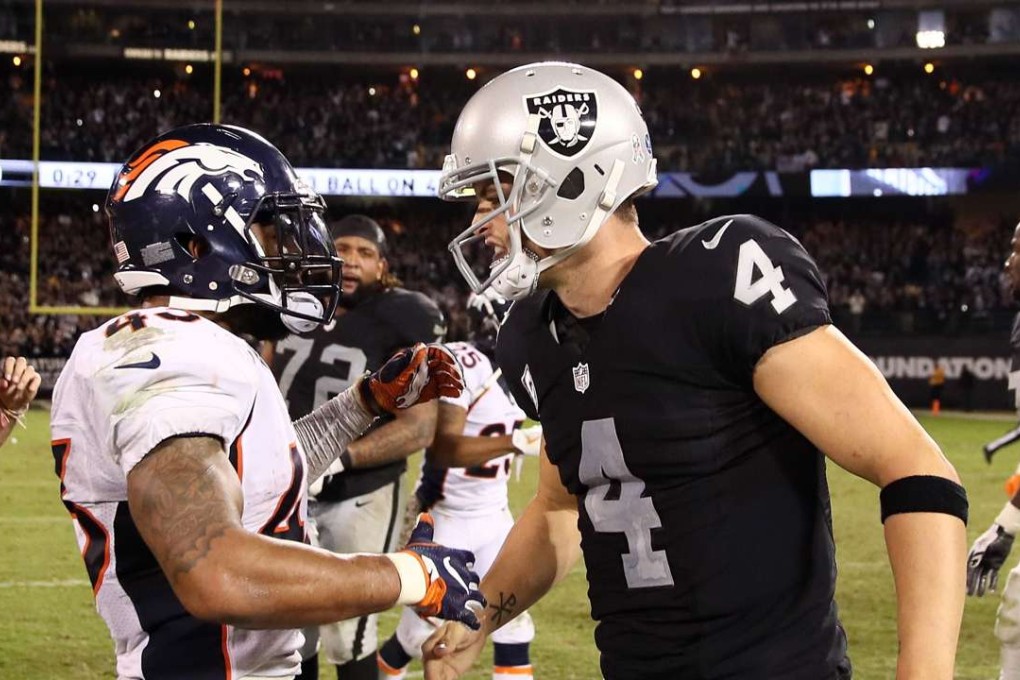 Derek Carr of the Oakland Raiders and T.J. Ward of the Denver Broncos talk after their game at Oakland-Alameda County Coliseum. Photo: AFP