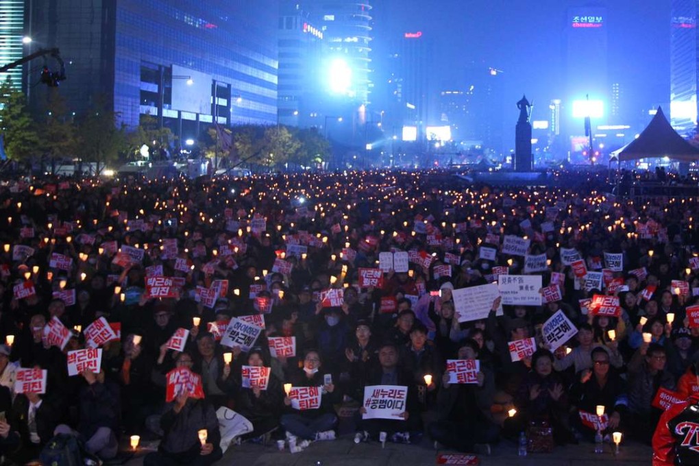 Protesters hold candle-lights as they attend a rally calling for the resignation of South Korean President Park Geun-hye in Seoul. Photo: Xinhua