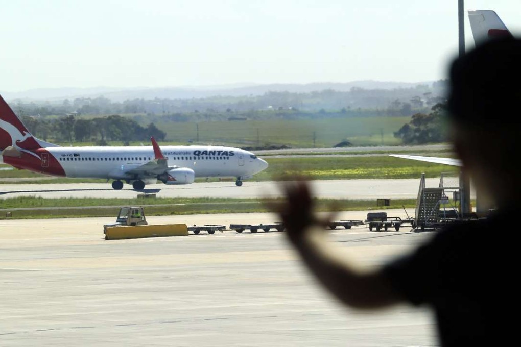 A young boy watching an aircraft belonging to Australian national air carrier Qantas taxing for takeoff at Tullamarine Airport in Melbourne. Photo: EPA