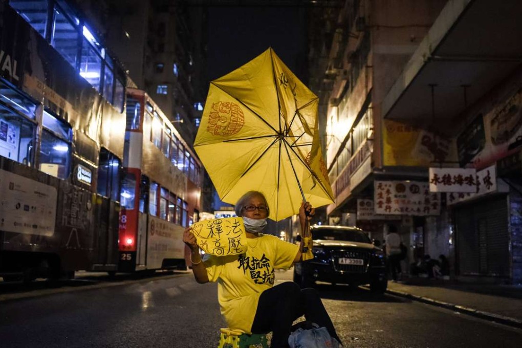 A protestor holds up a yellow umbrella in a street in Hong Kong on November 7, 2016. Hong Kong police used pepper spray November 6 to drive back hundreds of protesters angry at China's decision to intervene in a row over whether two pro-independence lawmakers should be barred from the city's legislature. Photo: AFP