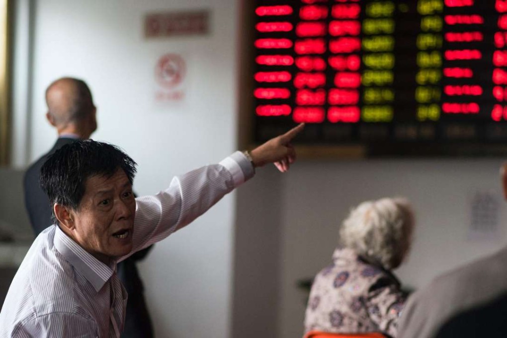 An investor gestures in front of the stock price movements on a screen at a securities company in Shanghai. Photo: AFP