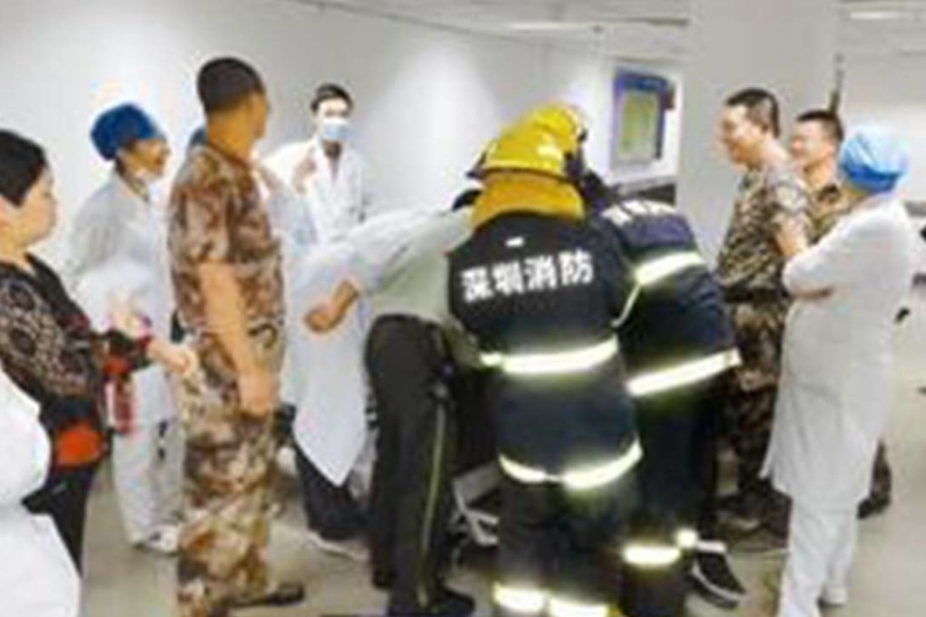 Firefighters removing the piercing gun from the man’s ear. Photo: SCMP Pictures
