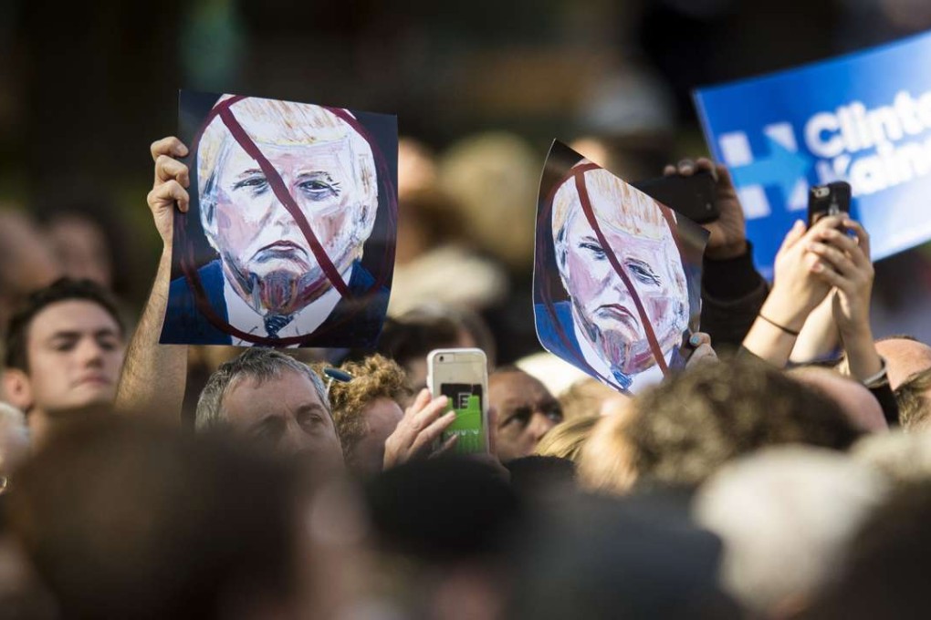 Attendees hold up signs against Donald Trump at a Hillary Clinton campaign event in Pittsburgh. Photo: Bloomberg