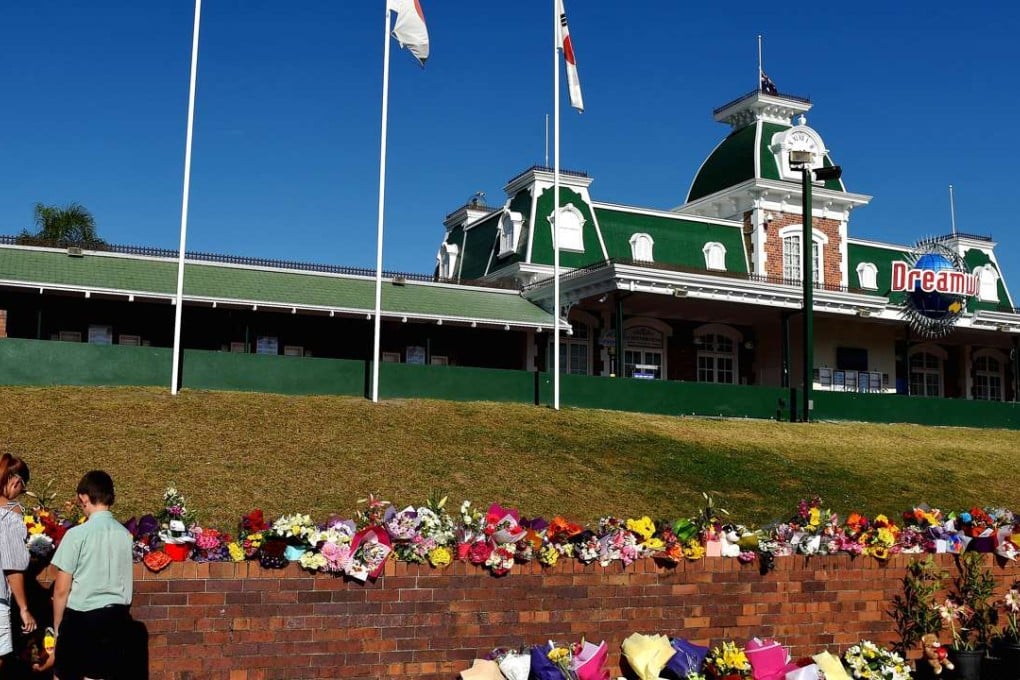 People leave floral tributes outside the main entrance to Dreamworld on Australia’s Gold Coast. Photo: Reuters