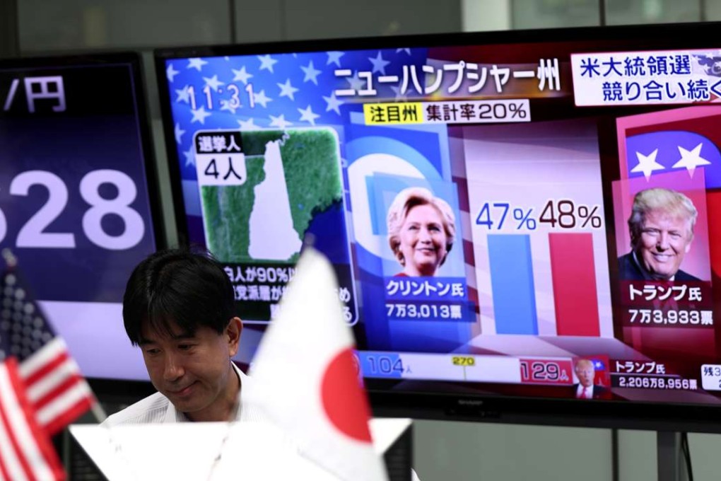 A Japanese worker at a foreign exchange trading company in Tokyo watches the US presidential elections unfold. Photo: AFP