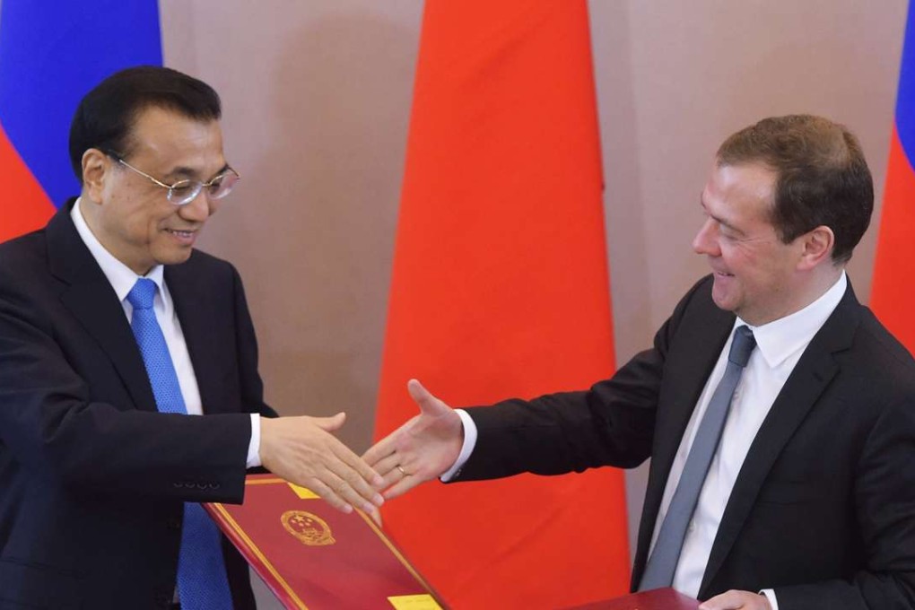 Premier Li Keqiang (left) shakes hands with Russian counterpart Dmitry Medvedev during a signing ceremony following their talks in St Petersburg. Photo: EPA