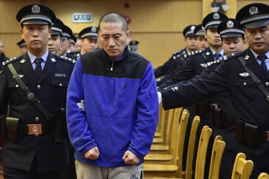 Yu Xuewei (centre), chairman of Ruihai International Logistics, is led into court by police officers at the start of his trial in Tianjin on Wednesday. Photo: Xinhua