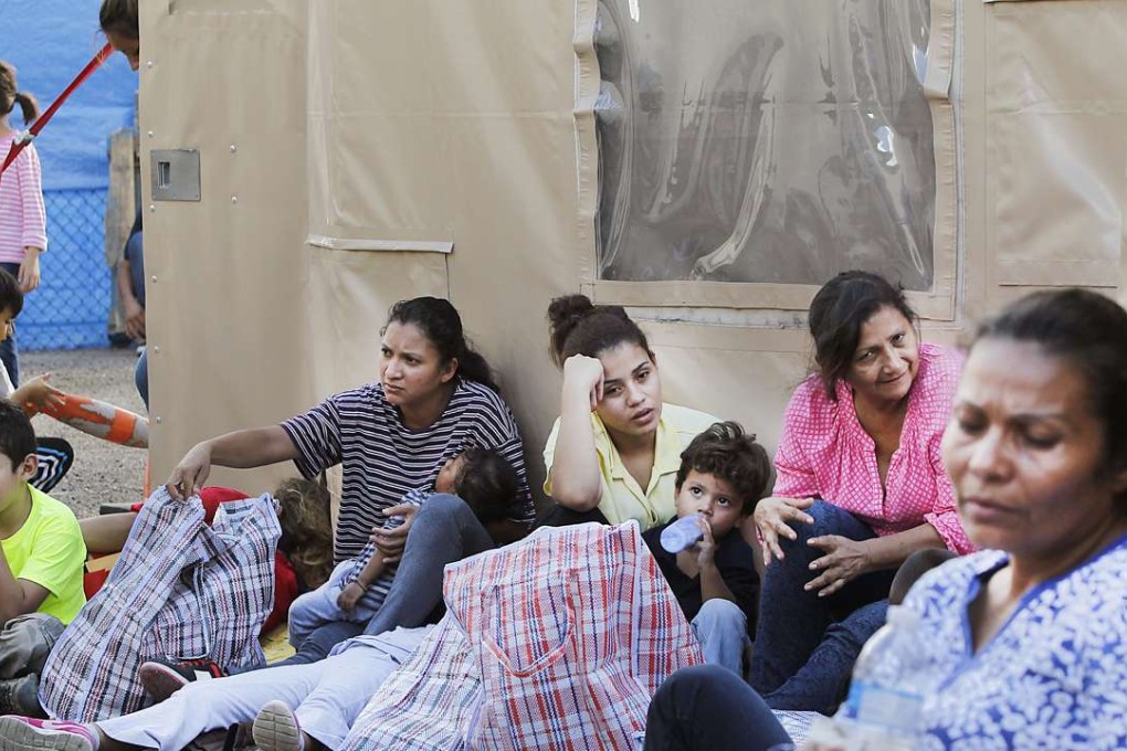Immigrants from Central America wait outside the portable tents at the Humanitarian Respite Center Sacred Heart Catholic Church in McAllen, Texas Photo: The Monitor via AP)
