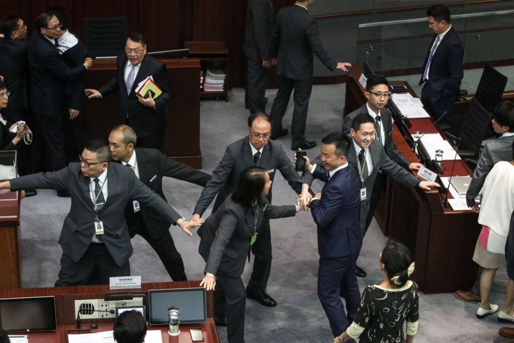 Legco fiddles while the people on the streets are revolting. Raymond Chan confronts security guards during the Legco presidential election session on October 12. Photo: Sam Tsang