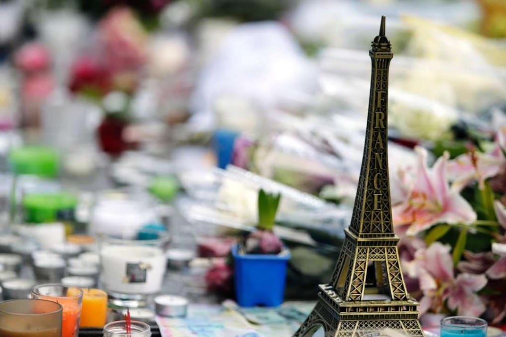 This file photo taken on November 17, 2015 shows a miniature Eiffel tower, candles and flowers displayed at a makeshift memorial outside Le Carillon cafe in Paris, in tribute to the victims of the terrorist attacks in which 130 people were killed and another 413 injured. Photo: AFP