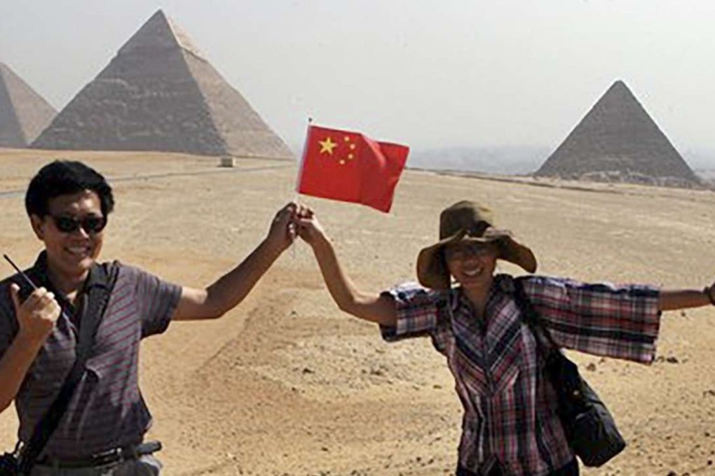 Chinese tourists posing in front of the Giza pyramids in Egypt. Photo: EPA