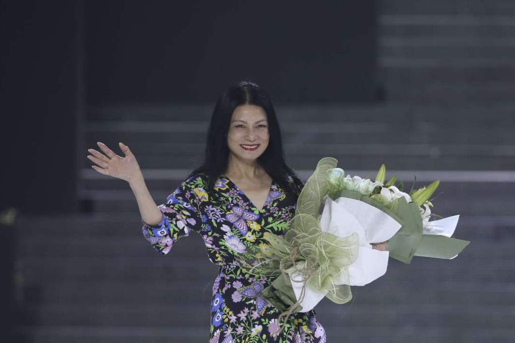 Designer Vivienne Tam takes a bow on the runway at her show in Beijing.