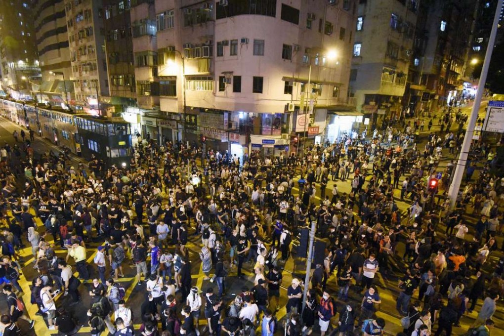 People take to the streets of Hong Kong on November 6, to protest Beijing's attempts to stop a fledgling independence movement. Police officers who formed a barricade to stop their advance resorted to using pepper spray on the protestors. Photo: KYODO