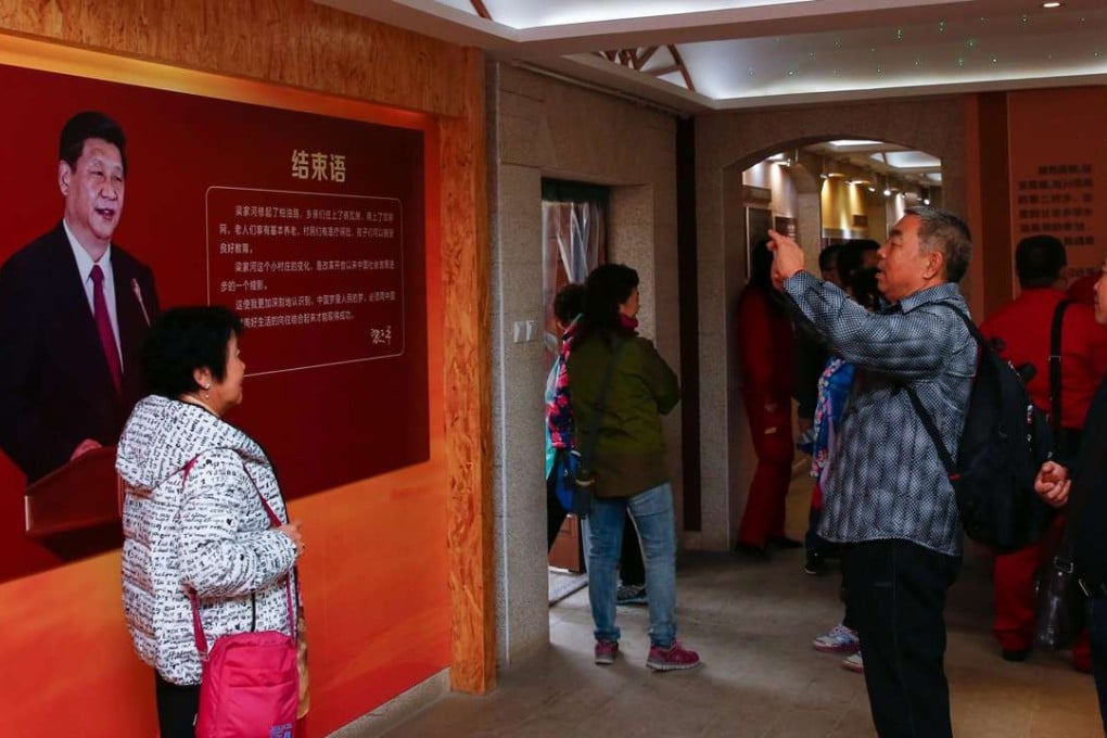 Visitors pose for photos in front of an image of President Xi Jinping at a museum in the village where Xi lived as a youth, in Liangjiahe, Shaanxi province. Photo: AFP