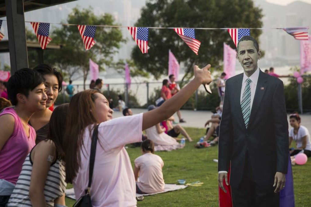 Friends take a selfie with a cardboard cut out of US president Barack Obama in Hong Kong. Photo: AFP