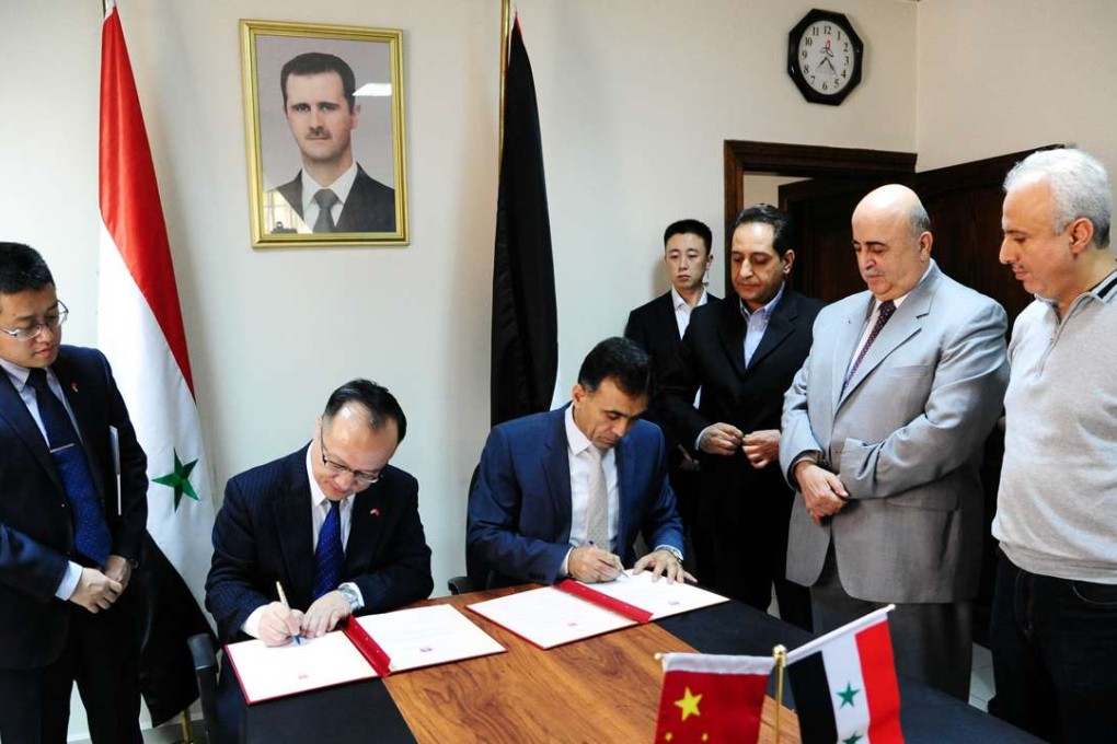 Chinese ambassador to Syria Qi Qianjin (second from left) signs a memorandum of understanding with Imad al-Azab in Damascus on Monday. Photo: Xinhua
