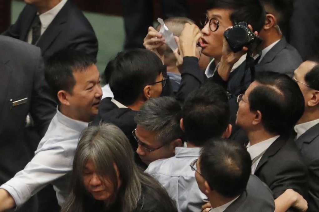 Pan-democrats join the scrum amid scuffles with Legislative Council security guards as they try to prevent Sixtus Leung (centre, holding a piece of paper) from retaking his oath on November 2. Photo: AP