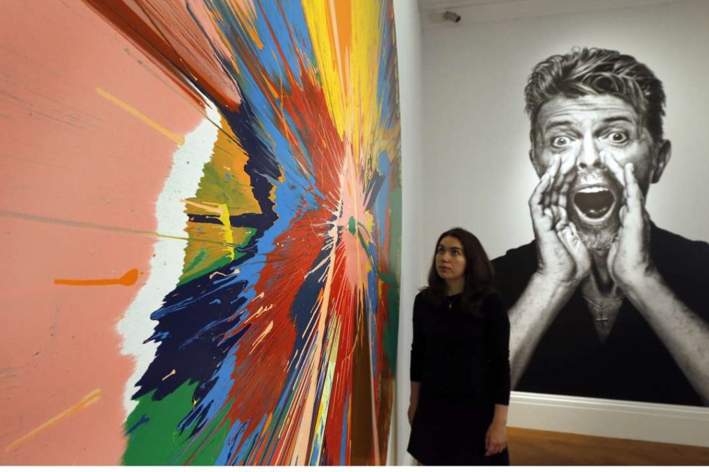 A photo of David Bowie (right) and a painting by Damien Hirst were among the artworks collected by the singer at a London auction this week. One work by Jean-Michel Basquiat went for US$8.8 million. The first part of Sotheby's two-part Bowie sale netted US$30.3 million, more than double its pre-sale estimate. Photo: AP