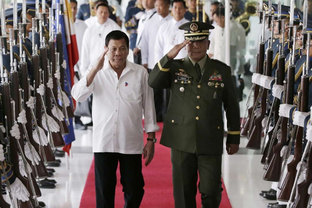 Philippine President Rodrigo Duterte, left, salutes with Philippine military chief Lt. Gen. Ricardo Visaya during departure honours at Manila's International Airport. Photo: AP