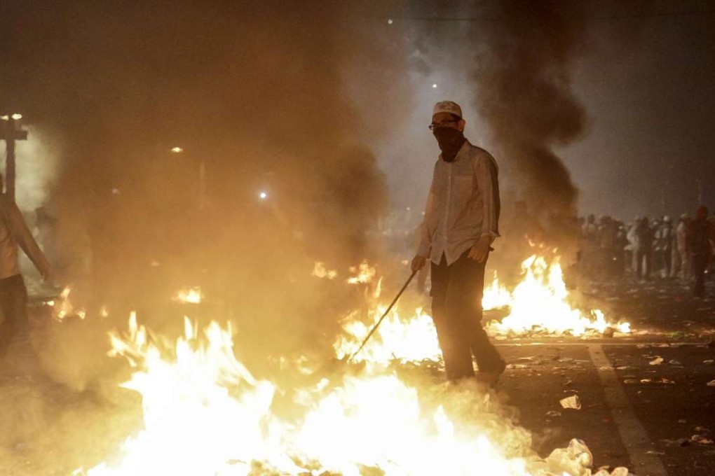 Flames rise as demonstrators clash with security forces during a protest against Governor Basuki ‘Ahok’ Tjahaja Purnama in front of the Presidential Palace in Jakarta. Photo: AFP