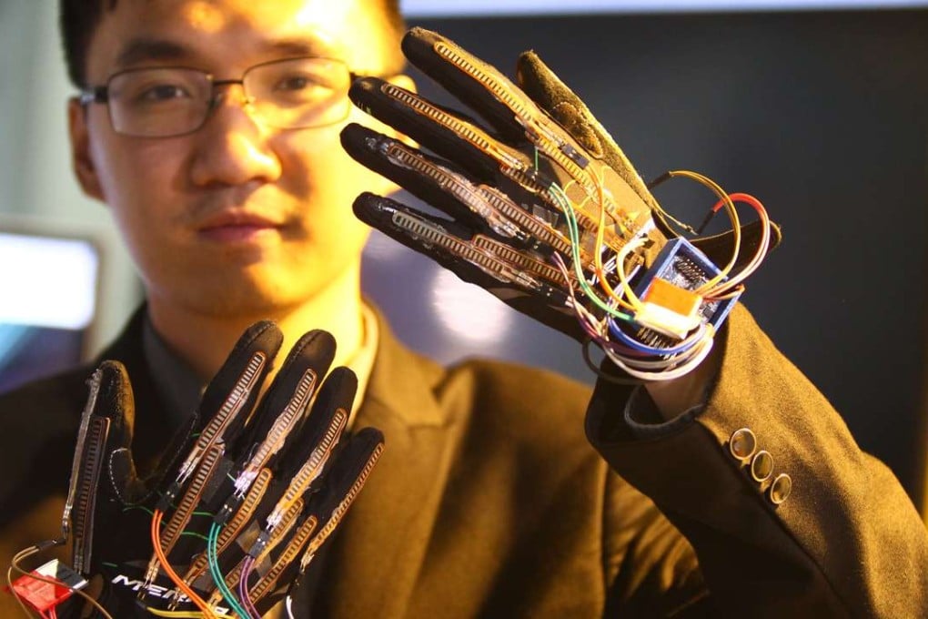 A staff member from Yingmi Tech, a firm based in Zhejiang province, shows off gloves developed with artificial intelligence technology that can do real-time translation of sign language into voice. The devices will be on display during the World Internet Conference in Wuzhen, which opened on Wednesday. Photo: Simon Song