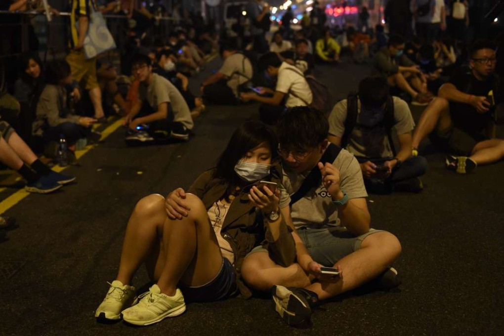 Protesters sit earlier this month on a main street which has been blocked off, amid demonstrations against Beijing’s decision to interpret the Basic Law provision on oath-taking. Photo: AFP
