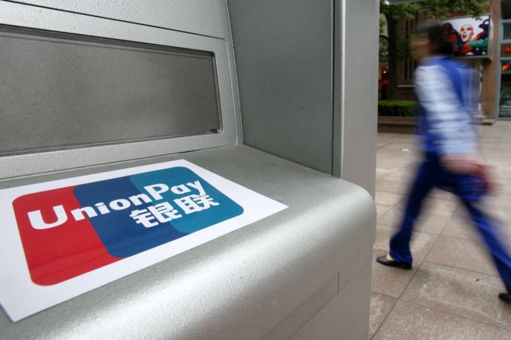 A pedestrian walks past a bank ATM machine with an UnionPay sticker in Shanghai, China. Photo: SCMP Pictures