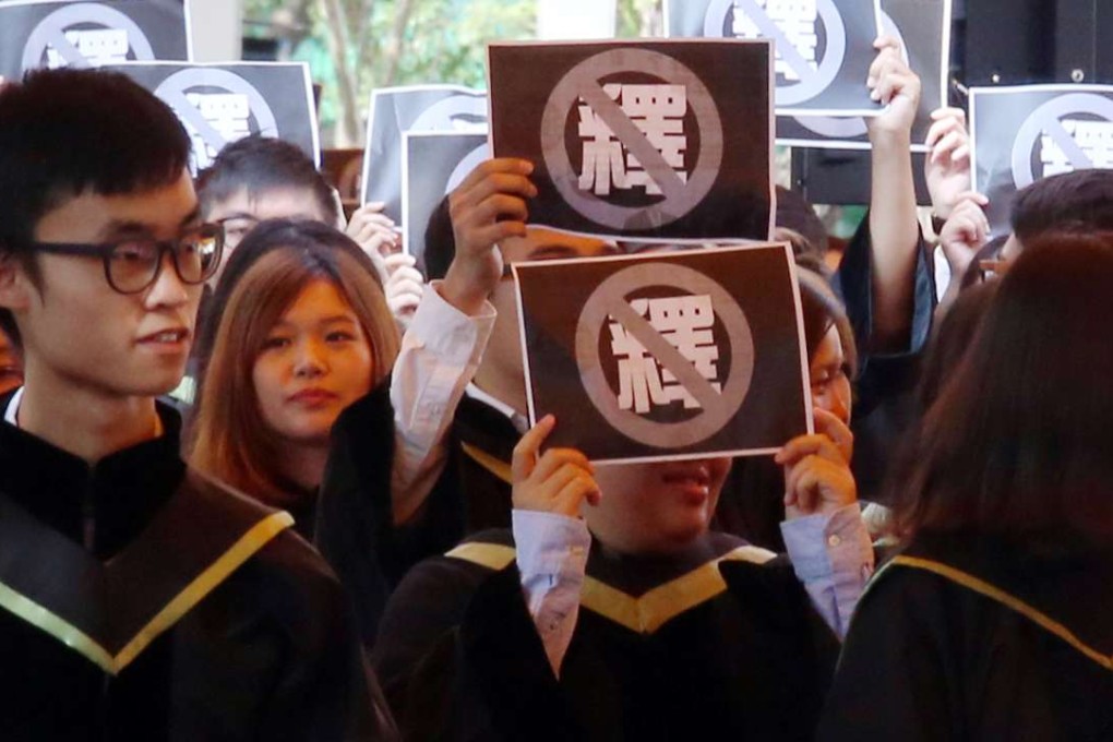 Students hold up signs during the ceremony. Photo: David Wong