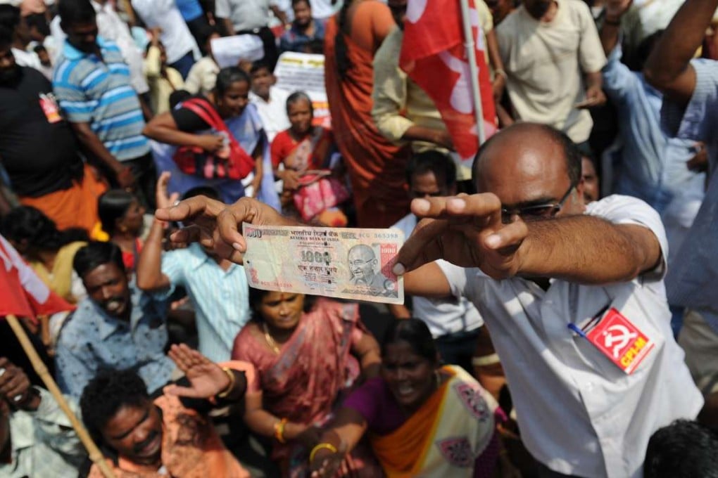 A member of the Communist Party of India displays a 1000 rupee note during a protest against Indian Prime Minister Narendra Modi and the withdrawal of the high-value banknotes from circulation. Photo: AFP/Arun Sankar