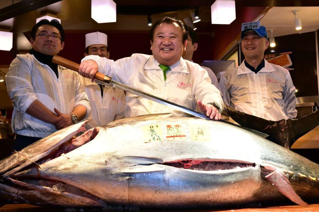President of sushi restaurant chain Sushi-Zanmai, Kiyoshi Kimura, witha 200kg bluefin tuna at his restaurant by Tokyo's Tsukiji fish market on January 5, 2016. The bluefin tuna was traded at 117,000 USD (14 million yen) at the wholesale market on the first trading day of the new year. Photo: AFP