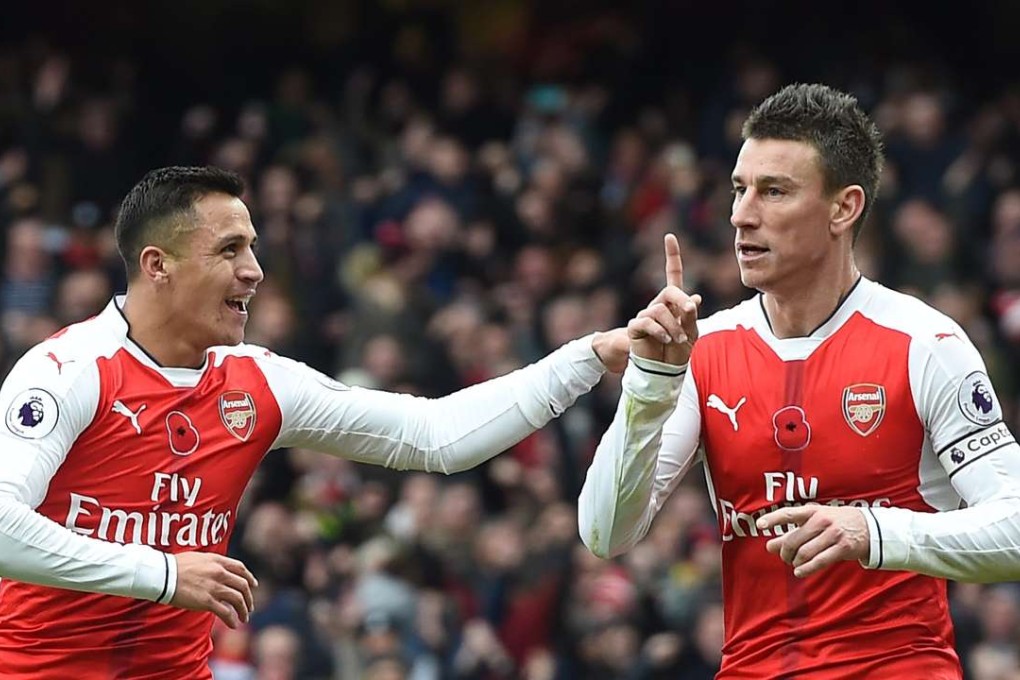 Arsenal's Laurent Koscielny (right) celebrates with Alexis Sanchez after Tottenham's Kevin Wimmer scored an own goal during their match on November 6. Photo: EPA