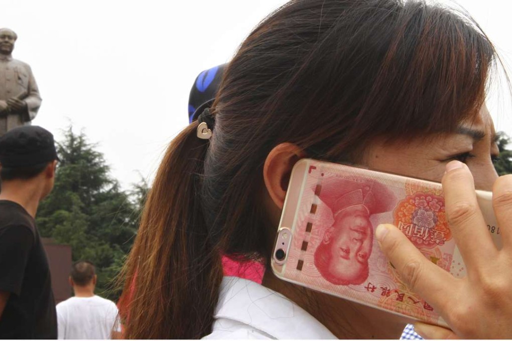Confidence in the yuan took a beating this week after it weakened beyond a key level. Photo: Simon Song women talks on her mobile phone which skin has the image of China's 100 yuan on Mao Zedong Square in Shaoshan, hometown of Mao Zedong in central China's Hunan province, on Sep 9, 2016. 09SEP16 Photo by Simon Song