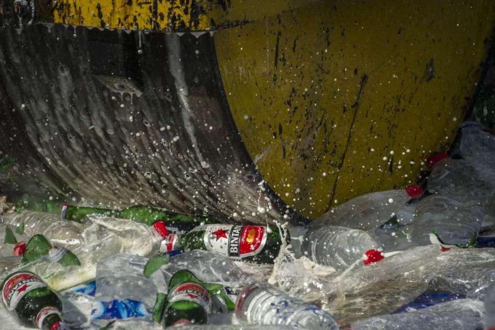 A steamroller runs over bottles of alcohol at a police station ahead of the holy month of Ramadan in Jombang, East Java, Indonesia. Photo: AFP