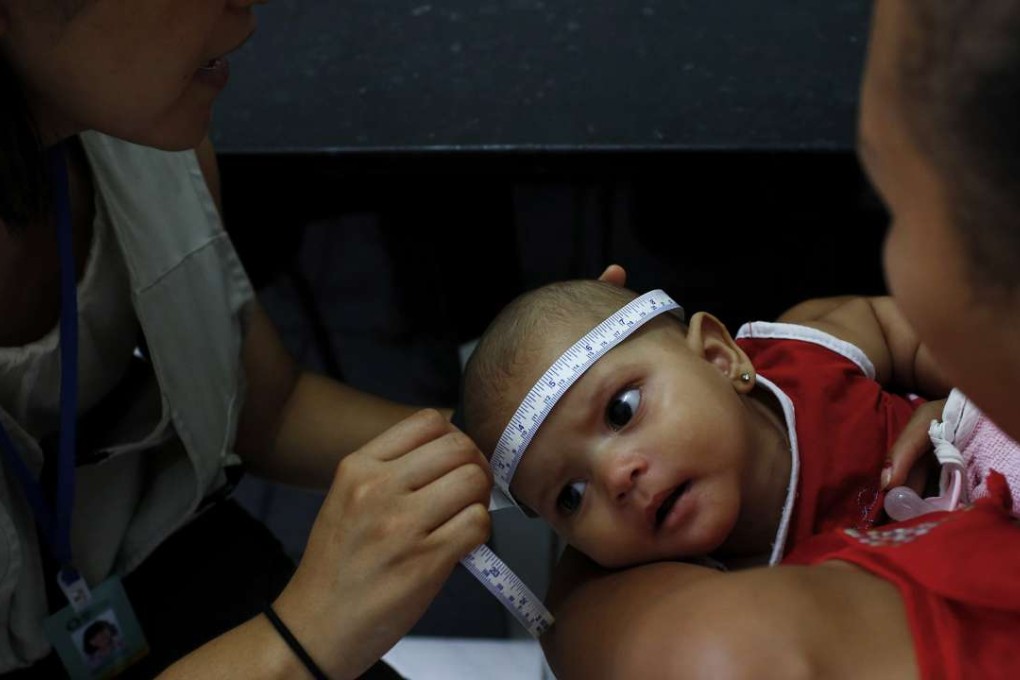 Dr. Megumi Itoh, left, an epidemic intelligence officer with the US Centers for Disease Control and Prevention (CDC), measures the head of 5-month-old Adrielly Rufino, as she is held by her mother, Maria Girdielly, 17, as part of the CDC and Brazil's Ministry of Health case-control study investigating the association between women having the Zika virus when they are pregnant, and the effects they are seeing of microcephaly in babies. Photo: Los Angeles Times/TNS