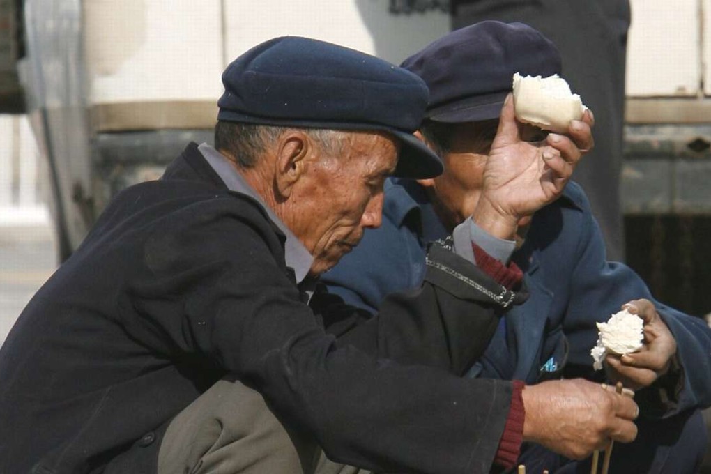 Migrant workers eat their lunch on a sidewalk in Beijing. The National Bureau of Statistics said there were more than 277 million migrant workers in China in 2015. Photo: EPA