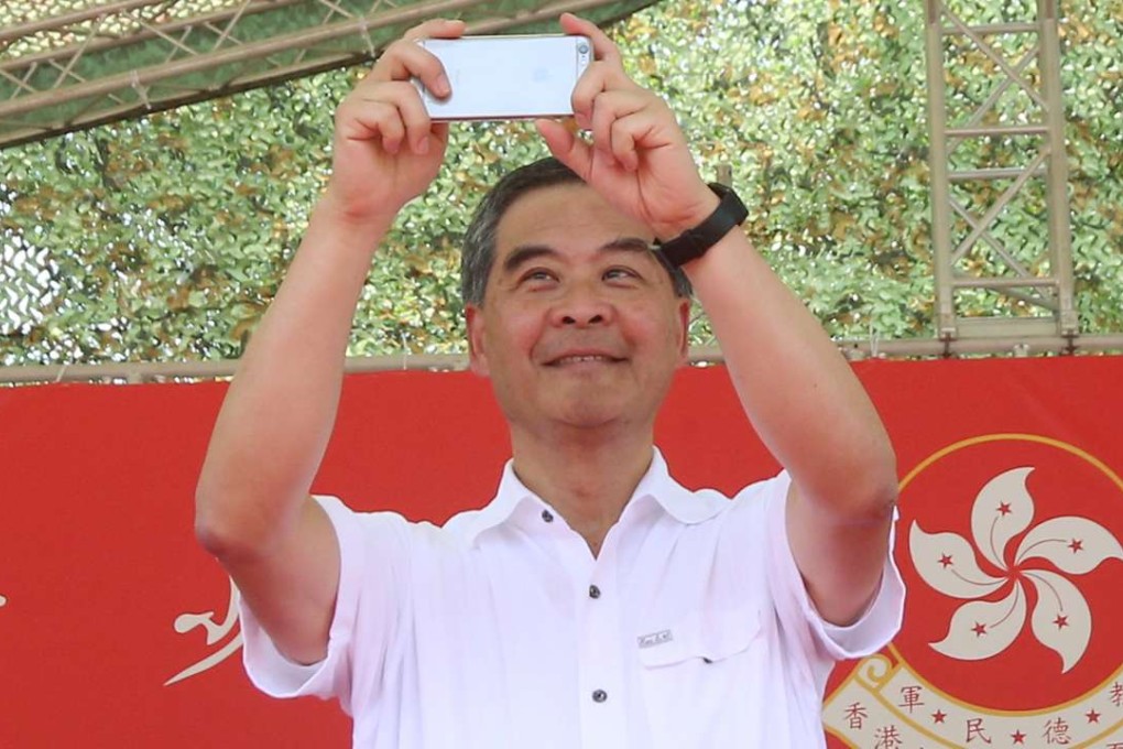 Chief Executive Leung Chun-ying takes some pictures on his phone at the graduation ceremony for military summer camp for HK youth in San Wai Barracks in Fanling.Photo: David Wong