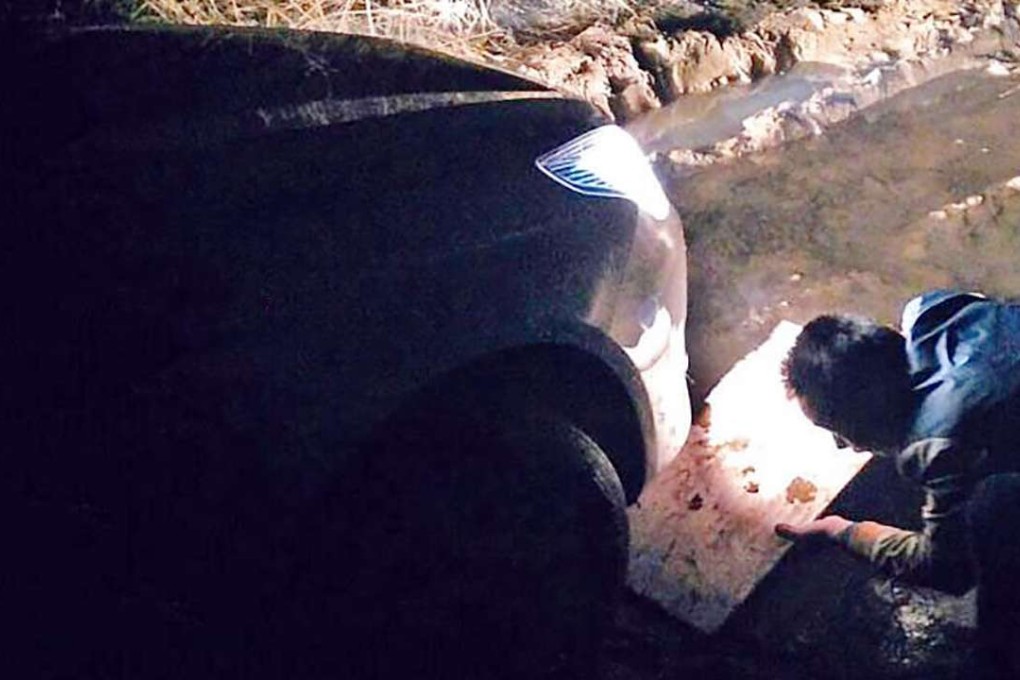 The stranded driver uses a conventional road map after his phone’s GPS route left his car stuck in a muddy ditch. Photo: SCMP Pictures