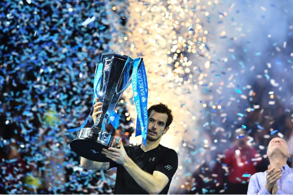 Britain's Andy Murray celebrate with the trophy after winning the men's singles final against Serbia's Novak Djokovic on the eighth and final day of the ATP World Tour Finals tennis tournament in London on November 20, 2016. / AFP PHOTO / Glyn KIRK
