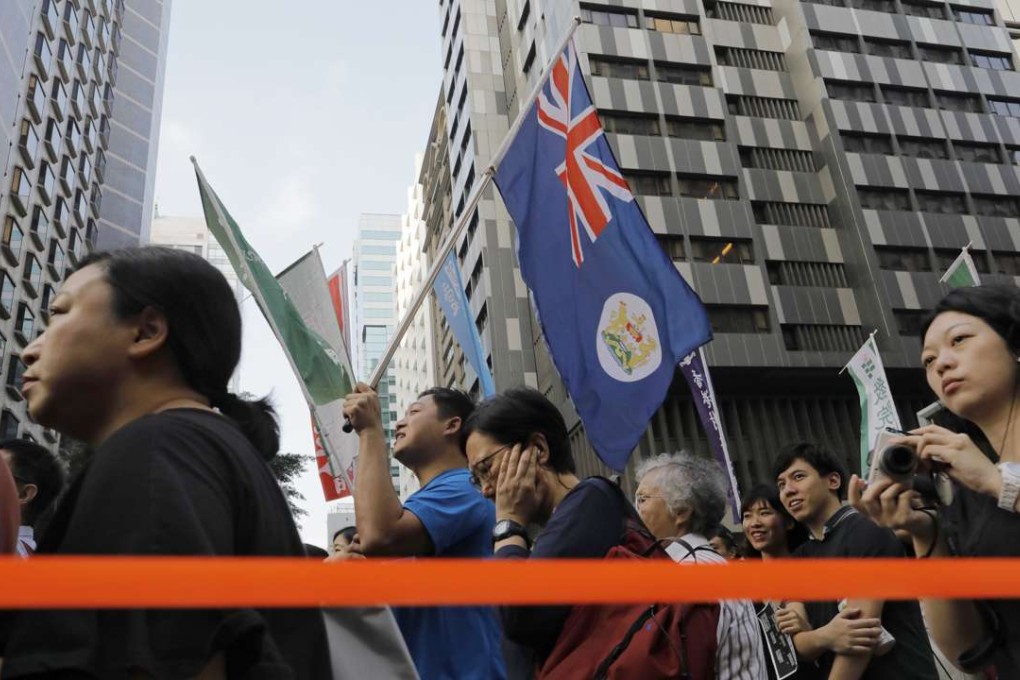 Protesters raise a Hong Kong colonial flag as thousands of people rally earlier this month against the latest NPC interpretation of the Basic Law. Photo: AP