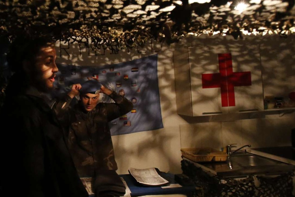 Bosnian Arian Kurbasic, right, the owner of the War Hostel in Sarajevo that offers visitors a unique opportunity to live like civilians in a war zone, talks to one of the guests. Photo: AP.