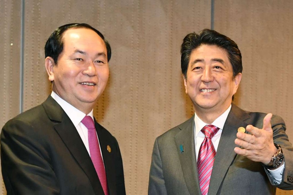 Japanese Prime Minister Shinzo Abe and Vietnamese President Tran Dai Quang shake hands in Lima. Photo: Kyodo