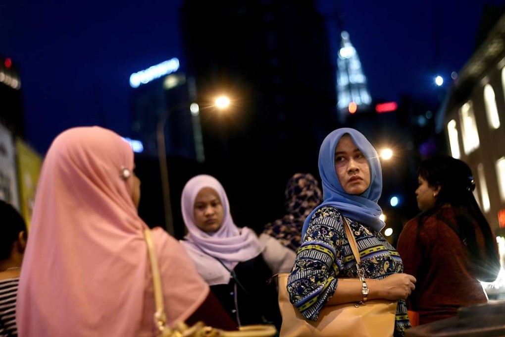 Malaysian women return from work in Kuala Lumpur. Malaysian PM Najib Razak has secured deals with China worth deals worth RM144 billion to the Malaysian economy. Photo: AFP